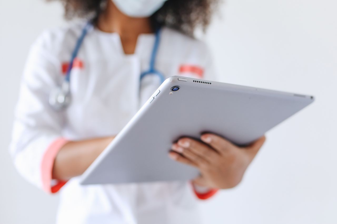 Services Close-up of a doctor wearing a mask using a tablet for healthcare management.